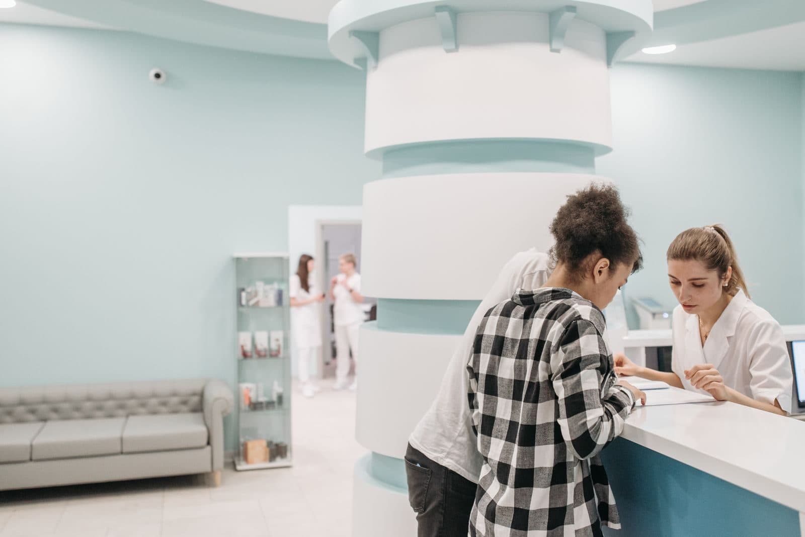 A patient discussing care and payment options with a staff member at the front desk