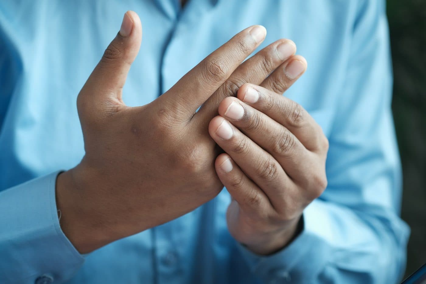 A person pressing one hand into the other to ease joint pain