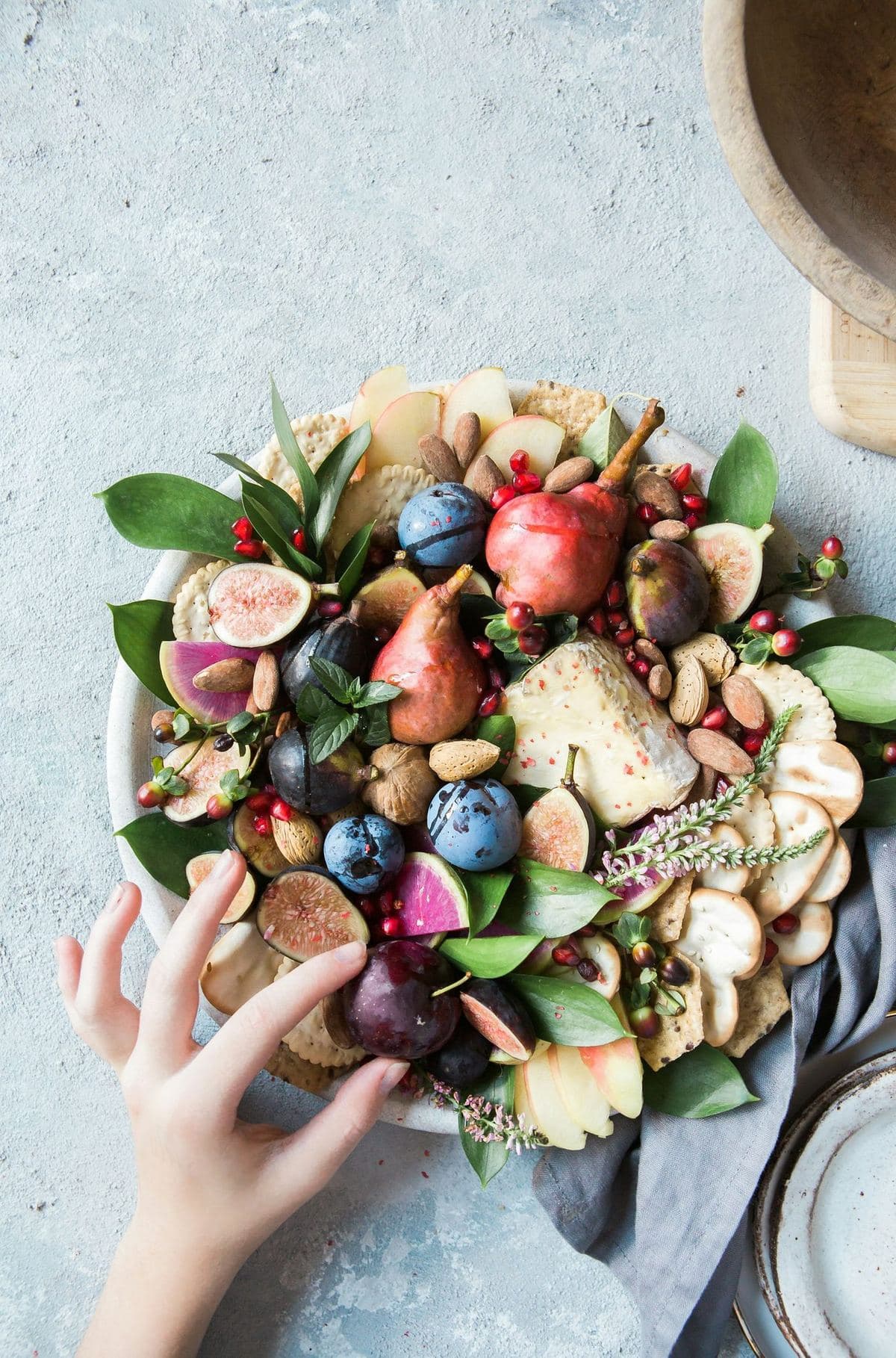 A platter of fresh fruit, nuts and cheese on a table