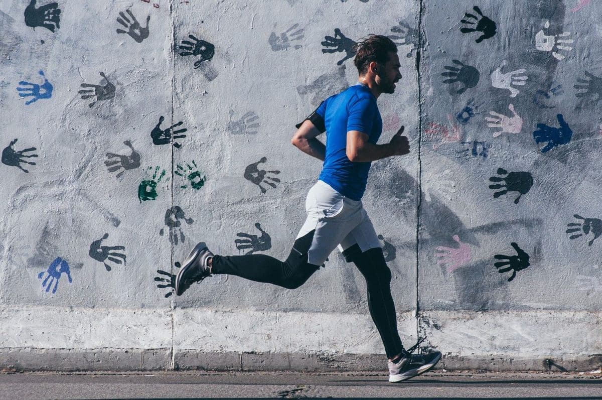 A person running along a city wall