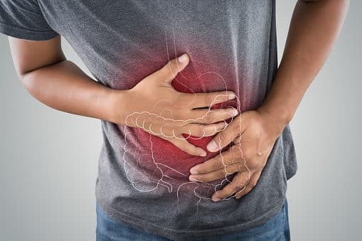 A person holding their abdomen, with the colon highlighted in an overlay