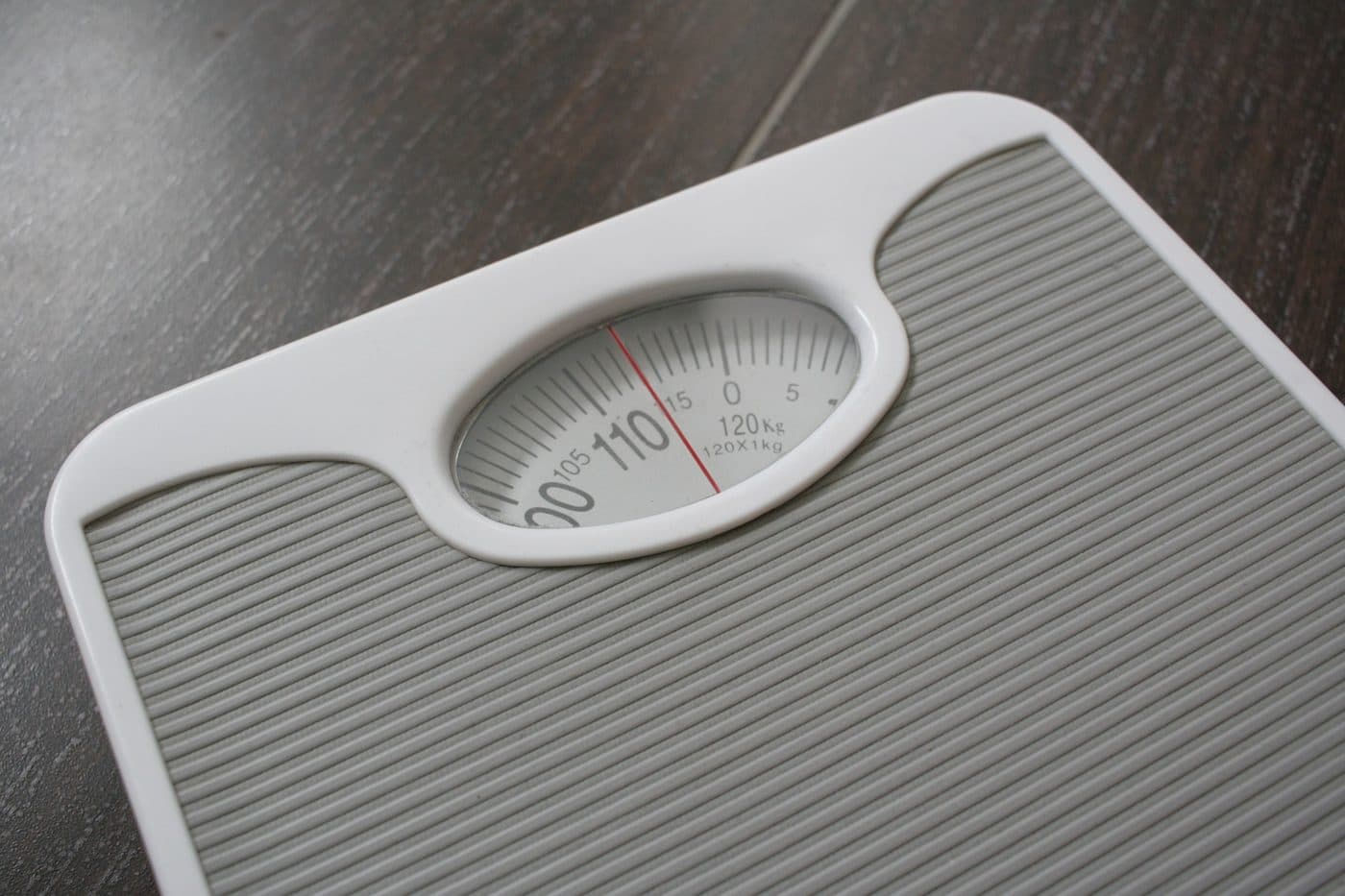 A bathroom scale on a wooden floor